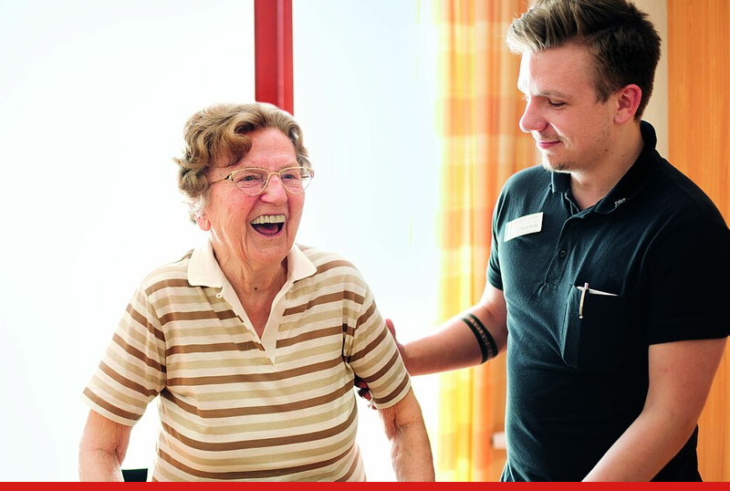 Ein Betheljahr-Teilnehmer begleitet eine ltere Dame in einer Senioren-Einrichtung